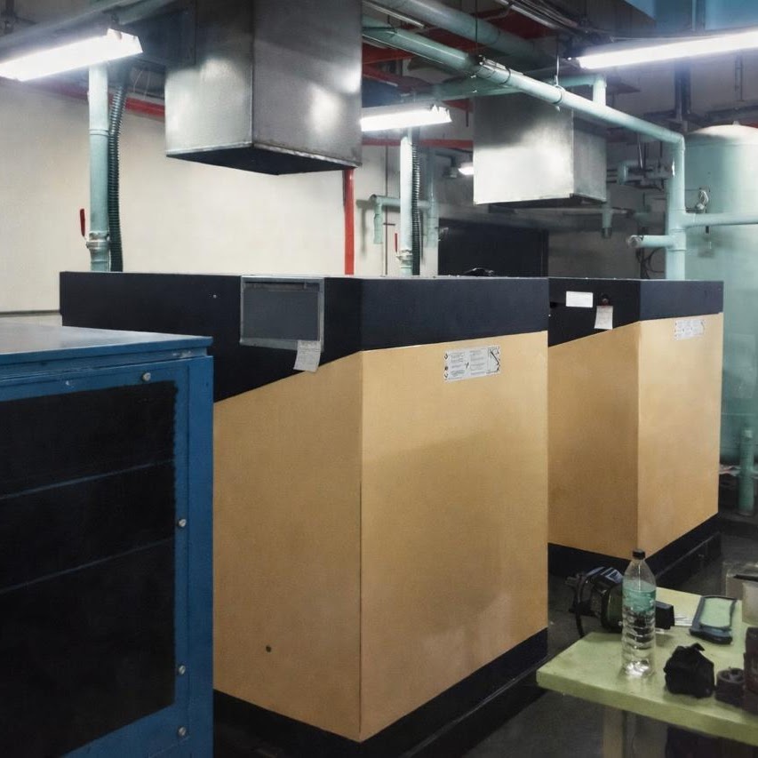Two Xinlei rotary screw compressors with a refrigerant air dryer installed in an indoor industrial plant room